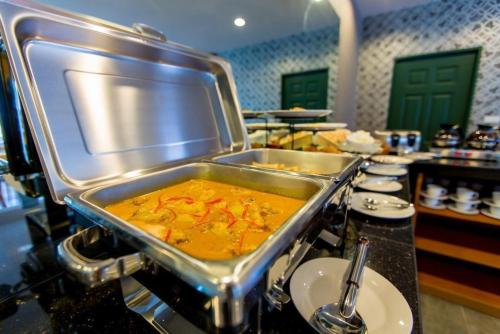 a kitchen with a large pot of food on a stove at Harmonize Hotel Chiang Mai in Chiang Mai