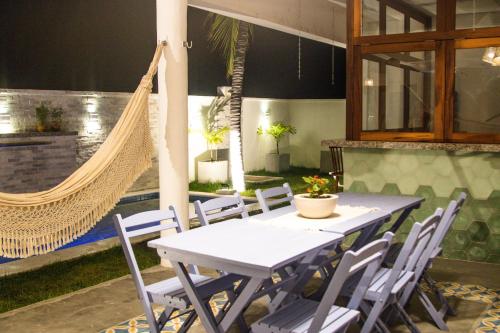 un tavolo con sedie e un'amaca sul patio di Casa Morica! Casa nova com Piscina! a Icaraí