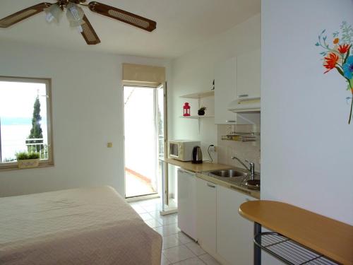 uma cozinha branca com um lavatório e uma mesa em Apartments Mari - 40 m from sea em Krilo