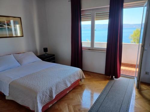 um quarto com uma cama e vista para o oceano em Apartments Mari - 40 m from sea em Krilo