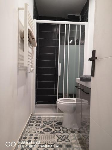 La salle de bains est pourvue de toilettes et d'une douche en verre. dans l'établissement LESAGE BIS, à Lorient