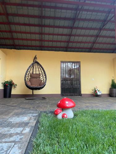a group of mushrooms in the grass with a bird cage at La Mimi Villa in Sadu