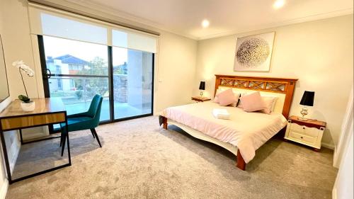 una camera con letto, scrivania e finestra di Luxury Waterfront Villa BBQ Cafe WiFi Great Views 5BRM a Point Cook
