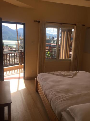 una camera da letto con un letto e un balcone con vista di Beli Guest House a Pokhara
