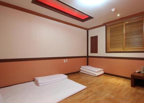 a room with two beds in it with a window at Utopia Hotel in Gumi