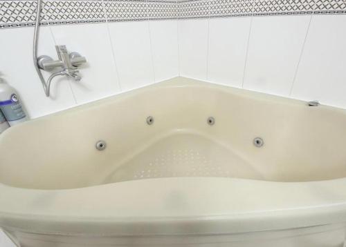 a white bath tub sitting in a bathroom at Utopia Hotel in Gumi