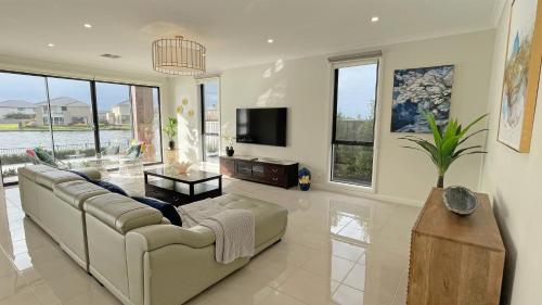 a large living room with a couch and a tv at Luxury Waterfront Villa BBQ Cafe WiFi Great Views 5BRM in Point Cook