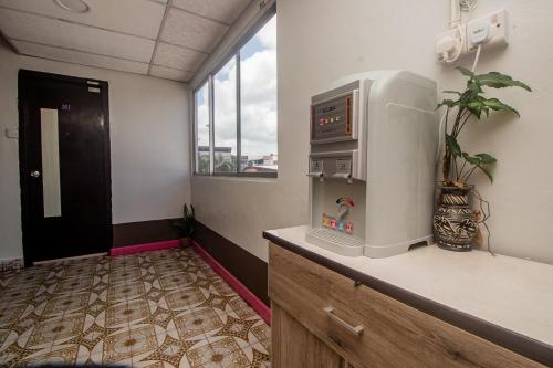 an office room with a refrigerator and a window at OYO 90124 Payang Puri Baru Hotel in Sarikei