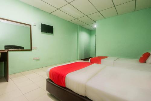sypialnia z dużym łóżkiem i czerwonym kocem w obiekcie OYO 90124 Payang Puri Baru Hotel w mieście Sarikei