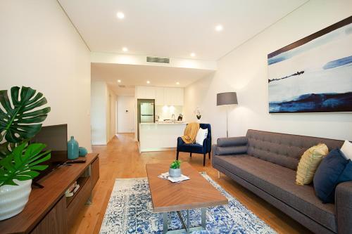 - un salon avec un canapé et une table dans l'établissement KULA North Sydney, à Sydney