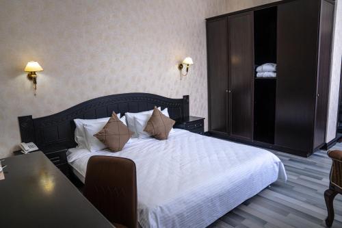 a bedroom with a large bed with white sheets and pillows at Belon Lux Hotel in Astana