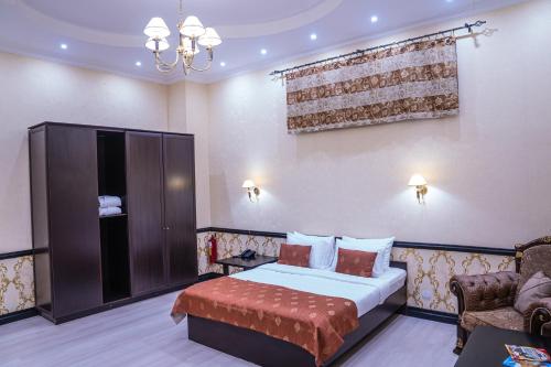 a bedroom with a bed and a couch and a chandelier at Belon Lux Hotel in Astana