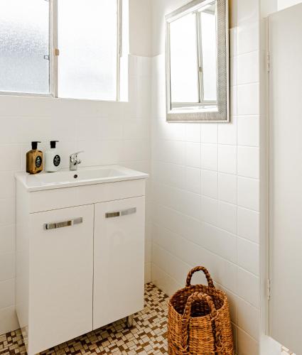 a bathroom with a sink and a wicker basket at Bay Breeze Boutique Accommodation in Batemans Bay