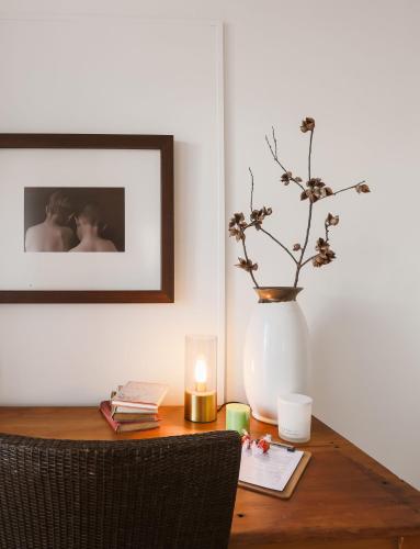 a wooden table with a vase and a candle on it at Bay Breeze Boutique Accommodation in Batemans Bay