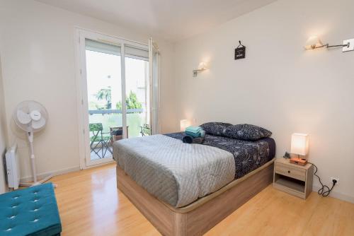 a bedroom with a bed and a large window at Les jardins de Rangueil, Parking, Métro, Piscine in Toulouse
