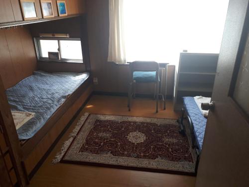 mały pokój z 2 łóżkami i dywanem w obiekcie Guest House Nagasaki Vogelnest w mieście Nagasaki