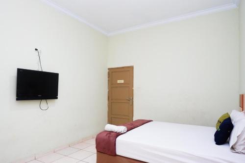 a bedroom with two beds and a flat screen tv at Urbanview Hotel Platinum Parepare in Parepare