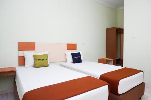two beds in a hotel room with two beds at Urbanview Hotel Platinum Parepare in Parepare