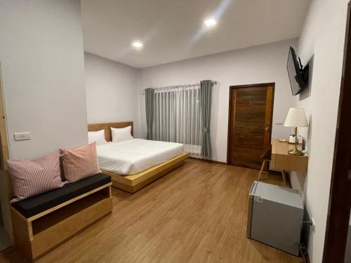 Intha Resort في Ban Khao Lao: غرفة نوم بسرير واريكة في غرفة
