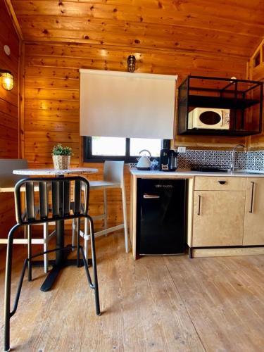 a kitchen with a table and a black refrigerator at ווילו בערבה in ‘En Yahav