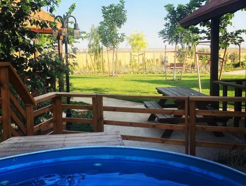 a hot tub in a backyard with a table and a fence at ווילו בערבה in ‘En Yahav