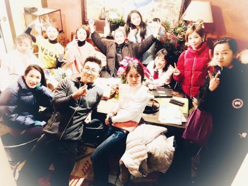 a group of people sitting around a table posing for a picture at 京町家-椿庵Kyomachiya-Tsubakian in Kyoto