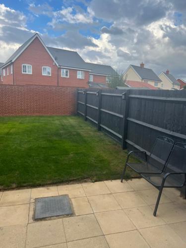 a bench sitting in a yard next to a fence at My Chester Luxury Home in Colchester