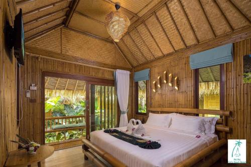 sypialnia z łóżkiem w pokoju z drewnianymi ścianami w obiekcie Phi Phi CoCo Beach Resort - SHA Extra Plus w Ko Phi Phi