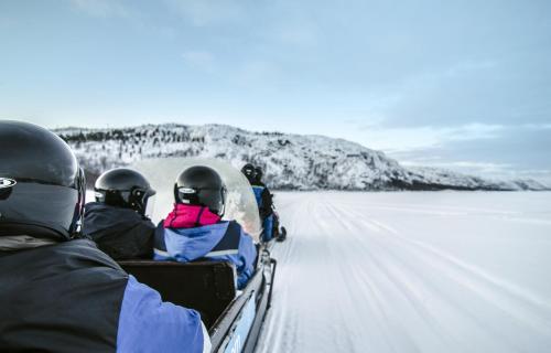 a group of people are riding in a zodiacarmaarmaarmaarmaarmaarma at Snowhotel Kirkenes in Kirkenes