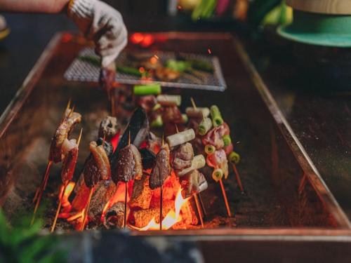 a person is cooking food on a grill at Kominkayado LOOF Sannoie in Koike