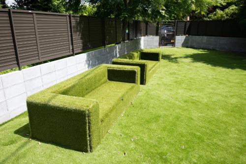two bushes sitting on the grass in a yard at Kominkayado LOOF Sannoie in Koike