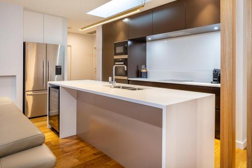 a kitchen with a white counter and a refrigerator at Penthouse On The Promenade in Batemans Bay