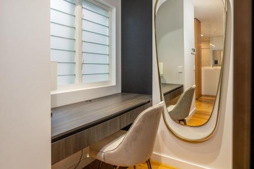 een kleedkamer met 2 stoelen en een spiegel bij Penthouse On The Promenade in Batemans Bay