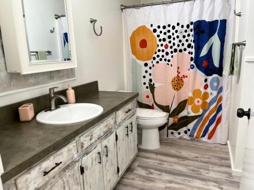 a bathroom with a sink and a toilet and a shower curtain at Cheerful 3 Bedroom on a Park 10 Miles from Eugene in Creswell