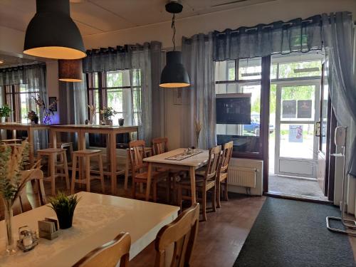a restaurant with tables and chairs and a bar at Hotelli Patruuna in Imatra
