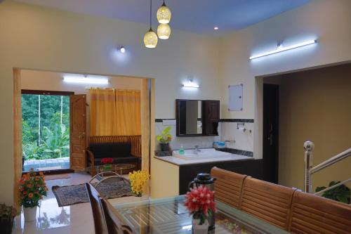 a kitchen and living room with a glass table at God's gift in Devikolam