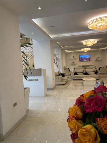 a lobby with a waiting room with couches and flowers at De Leopol Hotel in Addis Ababa