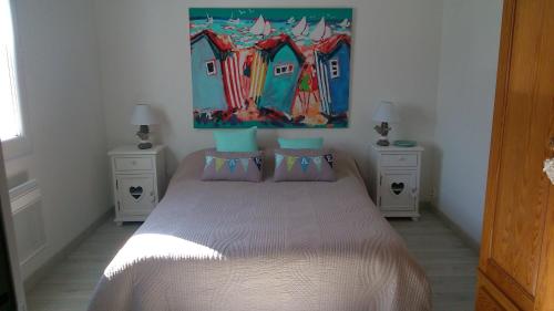 1 dormitorio con 1 cama con una pintura en la pared en Chambre d'Hôtes Armoise, en Lagord