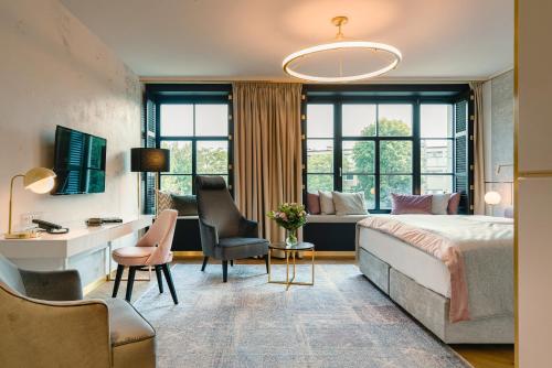 een hotelkamer met een bed, een bureau en een stoel bij Hotel Ferreus Modern Art Deco in Krakau