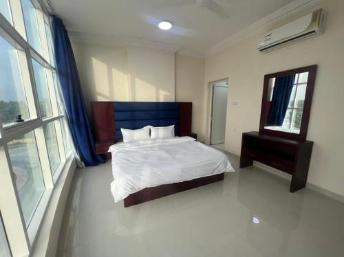 a bedroom with a large bed and a window at RED-25 - Razat Alard 4 in Salalah