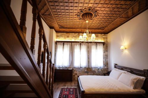 a bedroom with a bed and a chandelier at KERCULLA Resort in Gjirokastër