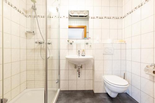y baño con aseo, lavabo y ducha. en Gästehaus Cafe Andrea en Köflach