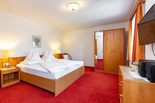ein Hotelzimmer mit einem Bett und einem TV in der Unterkunft Gästehaus Cafe Andrea in Köflach