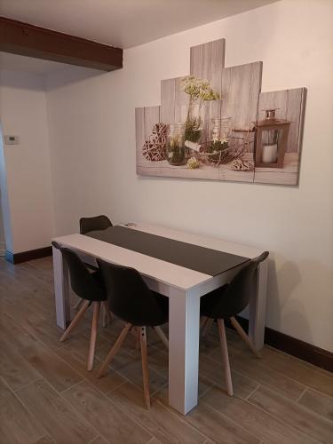 une table dans une pièce avec deux chaises et un tableau dans l'établissement Maison T2 à 6 minutes à pied du centre de Sarlat, à Sarlat-la-Canéda