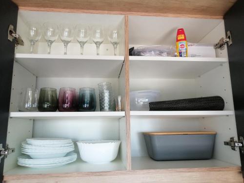 a cupboard filled with glasses and plates and dishes at Mobile Home Livanda in Klenovica