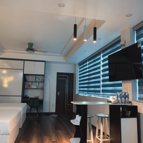 a living room with a bed and a table and a tv at Mio Hotel in Hải Dương