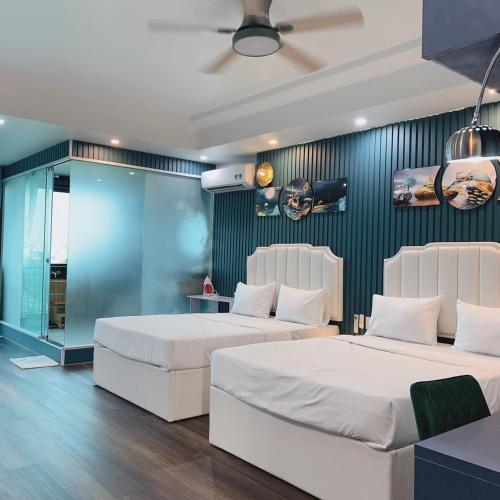 a bedroom with two beds and a blue wall at Mio Hotel in Hải Dương