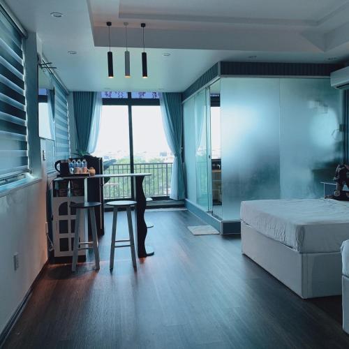 a bedroom with a bed and a table with a view at Mio Hotel in Hải Dương