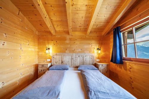 a bedroom with two beds in a log cabin at Bergchalet Refugium Martius in Marlengo