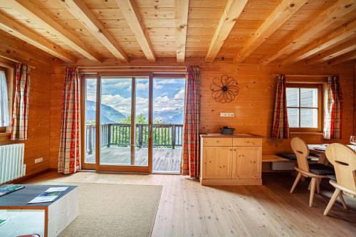 a living room with a table and a large window at Bergchalet Refugium Martius in Marlengo